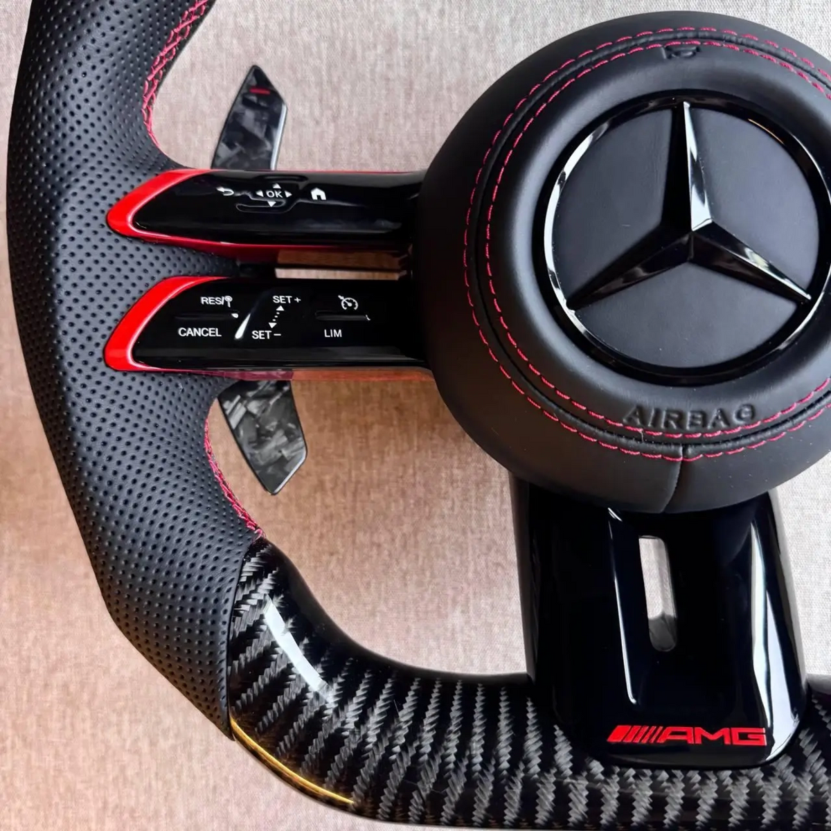 Volante Mercedes-AMG Carbono | Cuero Perforado, Costuras Rojas y Levas de Carbono