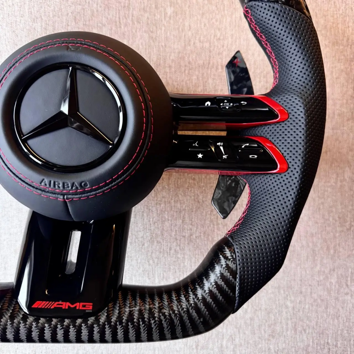 Volante Mercedes-AMG Carbono | Cuero Perforado, Costuras Rojas y Levas de Carbono
