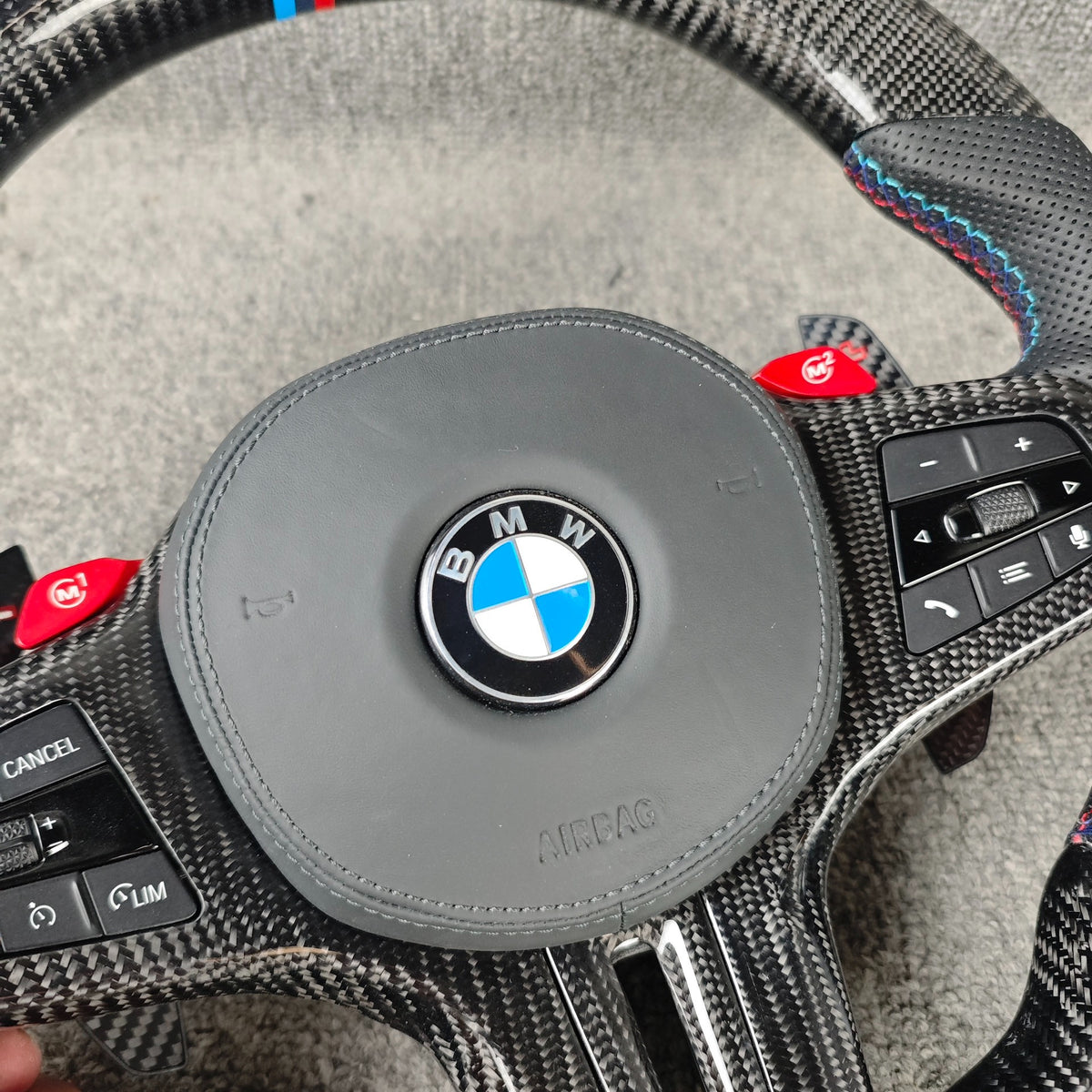 Volante BMW M deportivo en fibra de carbono, cuero perforado y botones M1/M2 con airbag incluido