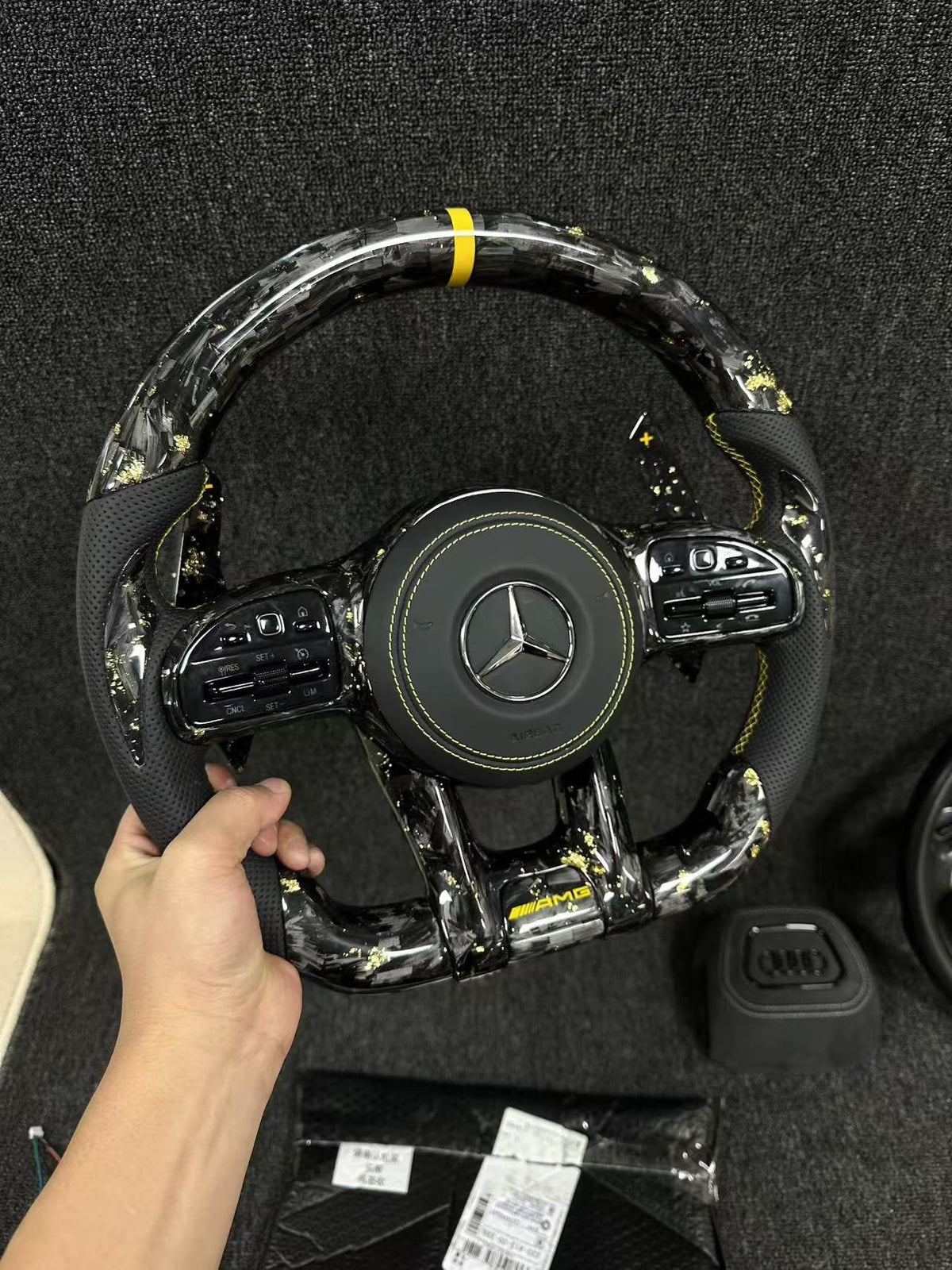 Volante Mercedes-AMG Performance en Fibra de Carbono, Microfibra Perforada, Levas y Costuras Amarillas