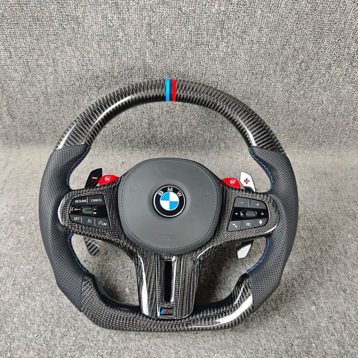 Volante BMW M deportivo en fibra de carbono, cuero perforado y botones M1/M2 con airbag incluido