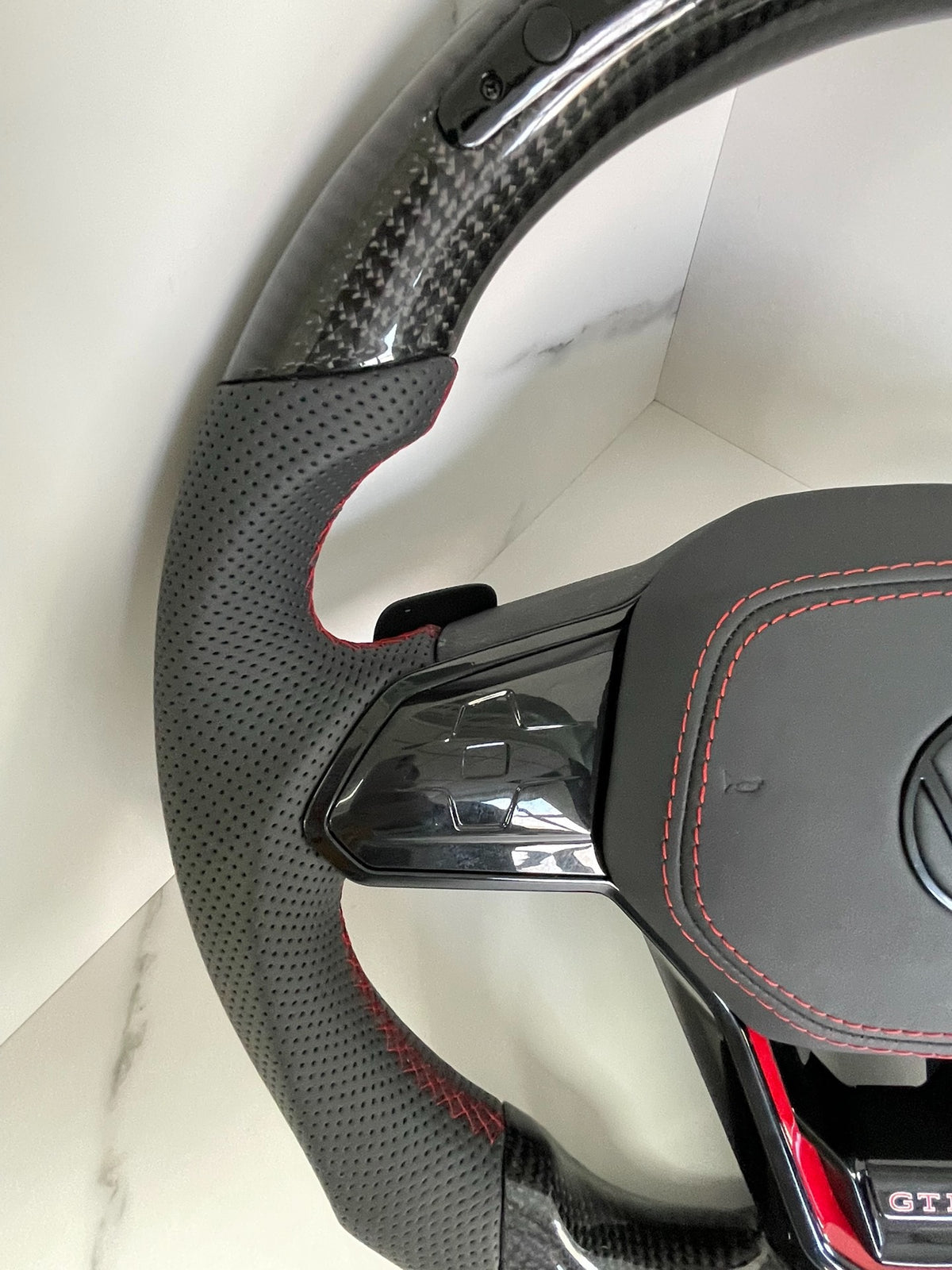Volante Volkswagen Golf GTI Performance en Fibra de Carbono, Cuero Perforado, Levas y Costuras Rojas