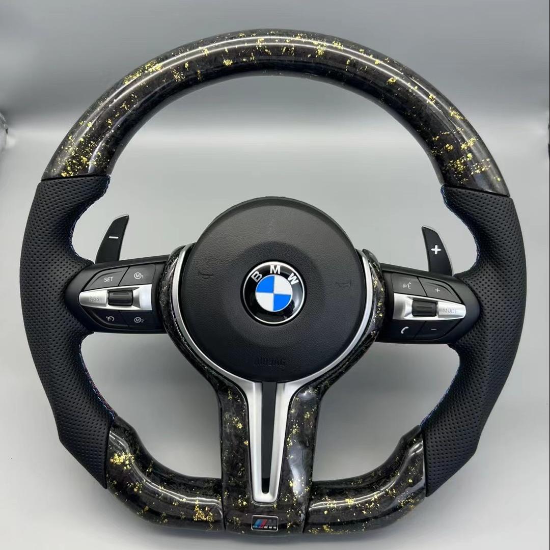 Volante BMW M Performance en Fibra de Carbono con Detalles Dorados, Cuero Perforado, Levas y M1/M2