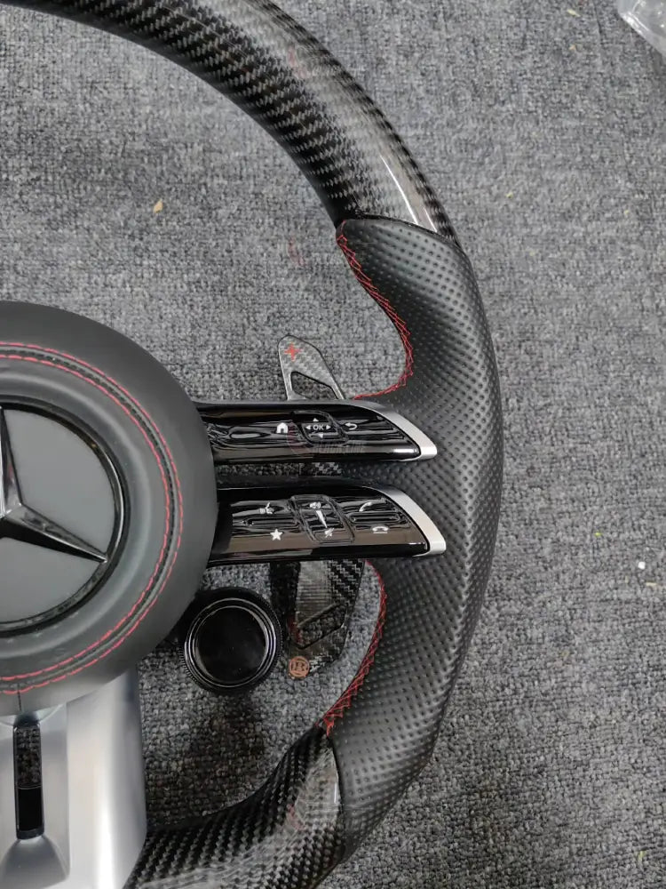 Volante Mercedes-AMG Deportivo en Carbono y Cuero Perforado | Fondo Plano Mandos Giratorios Levas y Airbag